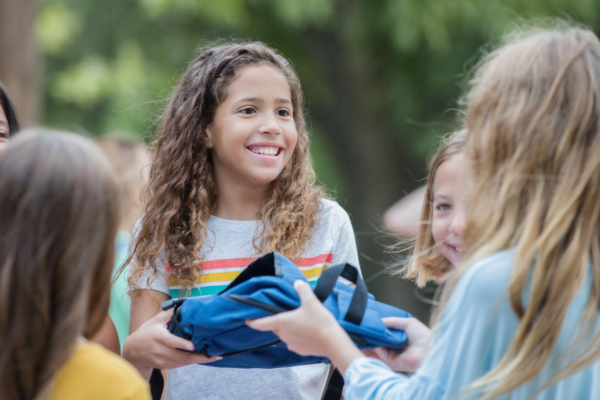 Child receiving a backpack full of supplies